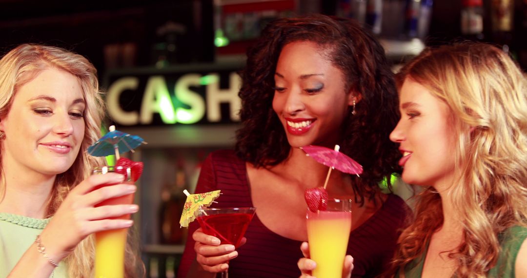 Friends Enjoying Colorful Cocktails at Bar with Happy Expressions