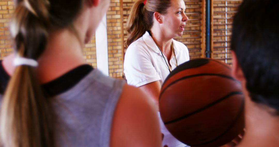 Female Coach Teaching Basketball Skills to Team in Gym - Free Images, Stock Photos and Pictures on Pikwizard.com