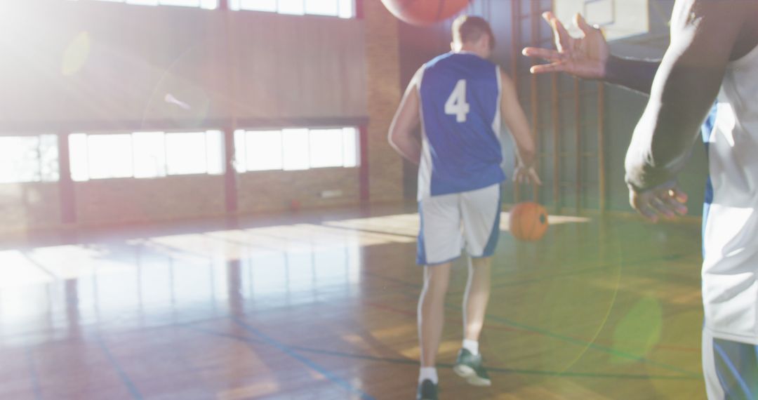 Diverse Basketball Team Practicing in Sunlit Gym