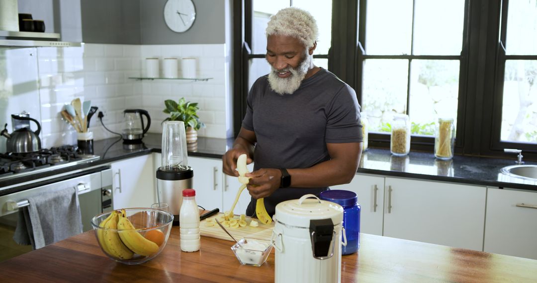Senior Man Preparing Healthy Banana Smoothie in Modern Kitchen
