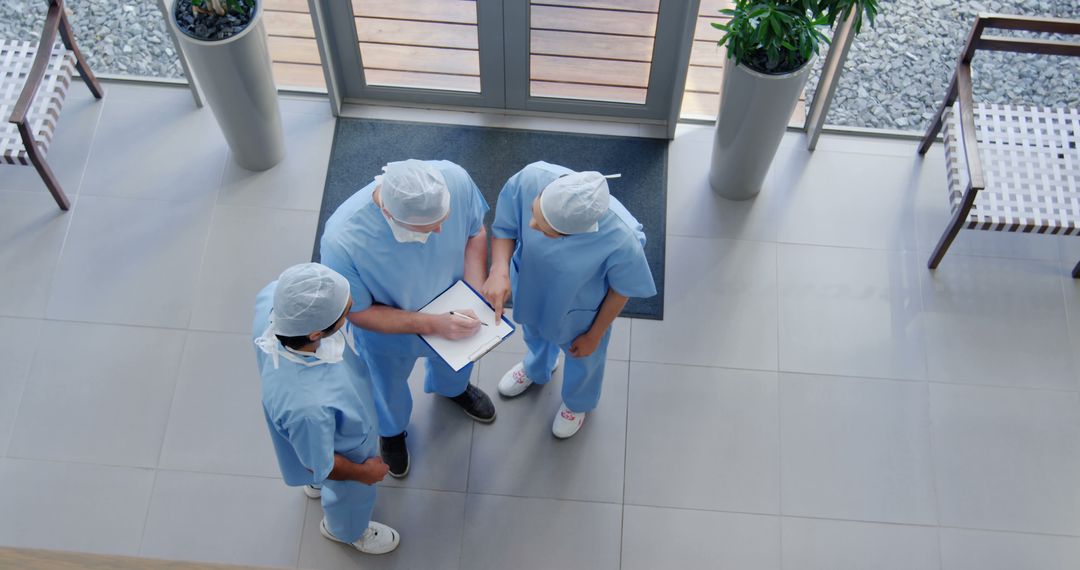 Healthcare Professionals Discussing Patient Care Plan in Hospital Lobby - Free Images, Stock Photos and Pictures on Pikwizard.com