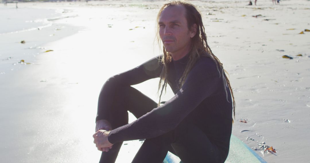 Surfer with Dreadlocks Sitting on Beach - Free Images, Stock Photos and Pictures on Pikwizard.com