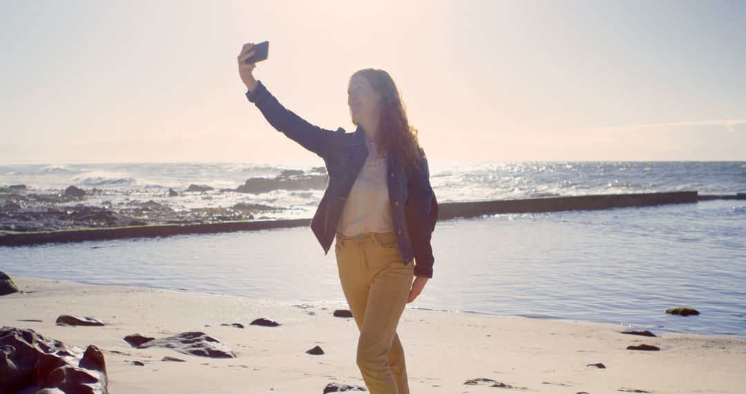 Young Woman Taking Selfie on Beach at Sunset - Free Images, Stock Photos and Pictures on Pikwizard.com