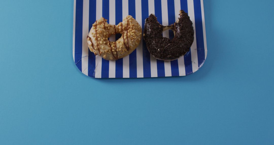 Two Delicious Donuts on Striped Tray Top View with Blue Background - Free Images, Stock Photos and Pictures on Pikwizard.com