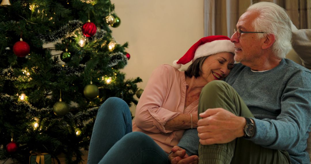 Senior Couple Embracing by Decorated Christmas Tree
