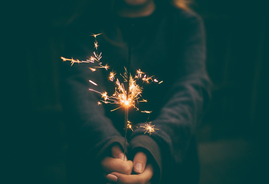 Person Holding Sparkler in Evening Darkness