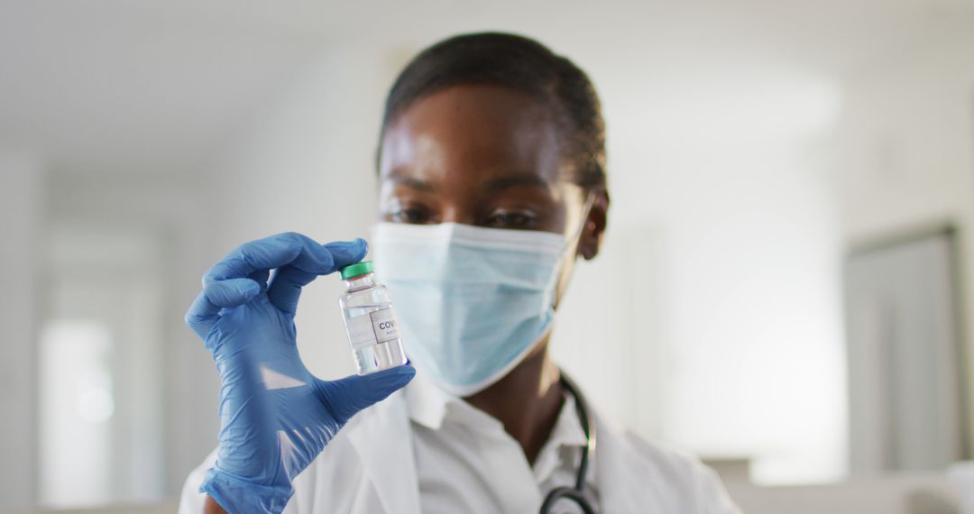 Female African American Doctor Examining COVID-19 Vaccine Vial in Hospital - Free Images, Stock Photos and Pictures on Pikwizard.com