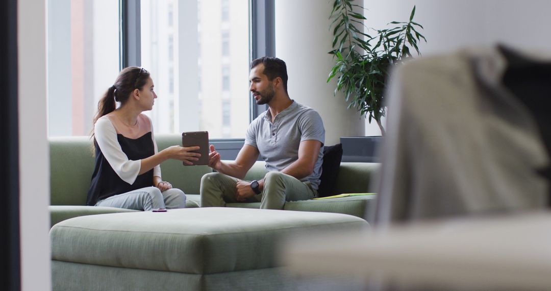 Colleagues Discussing Project on Tablet in Modern Office