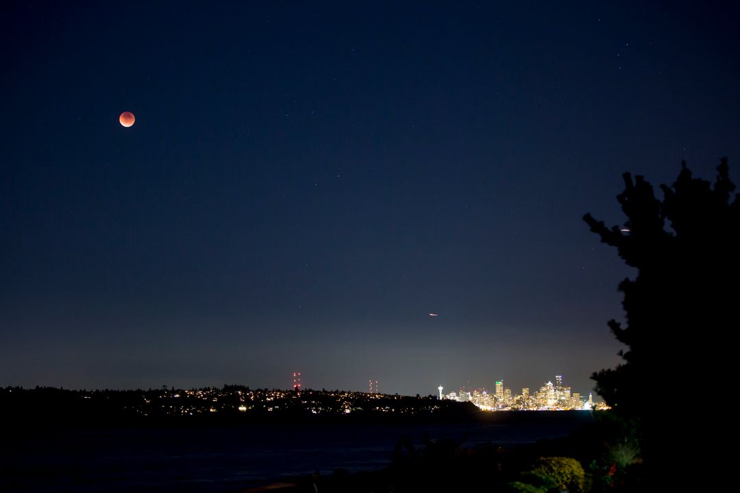 Lunar Eclipse Over City Skyline at Night - Free Images, Stock Photos and Pictures on Pikwizard.com