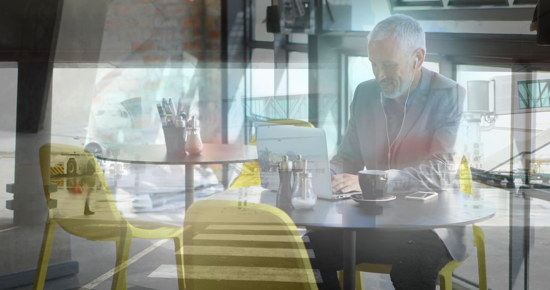 Senior Businessman Engaging with Laptop in Modern Space