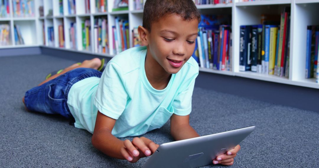 Young Boy Using Tablet in School Library Environment
