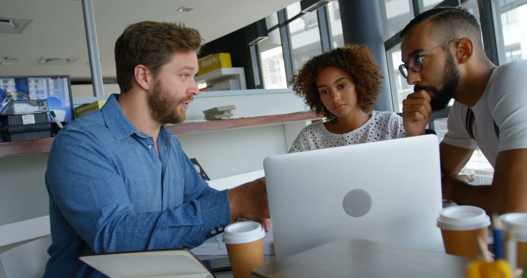 Team Collaborating on Laptop in Modern Office Space