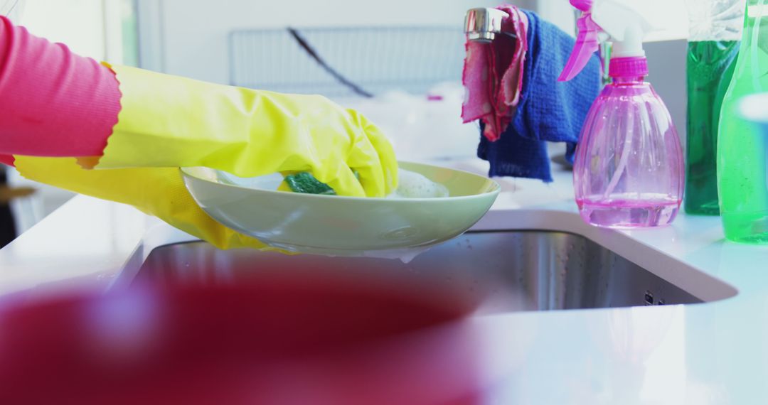 Person Washing Dishes with Yellow Gloves in Bright Kitchen - Free Images, Stock Photos and Pictures on Pikwizard.com