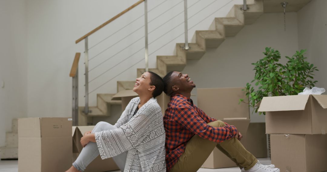 Happy Couple Relaxing with Moving Boxes in New Home