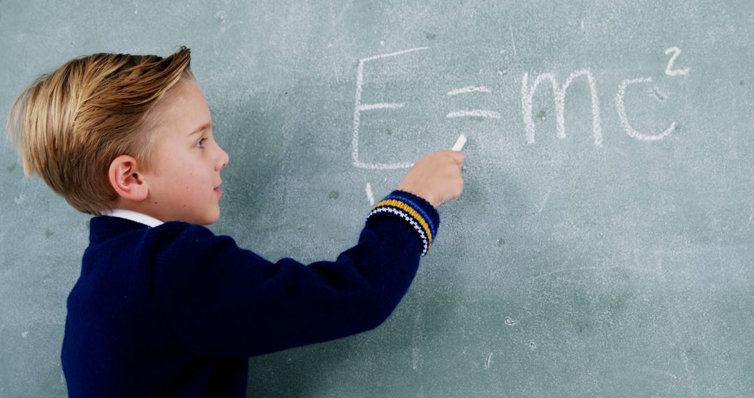 Young Boy Writing E=mc^2 on Chalkboard in Classroom - Free Images, Stock Photos and Pictures on Pikwizard.com