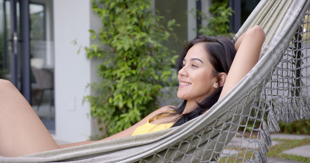 Woman Relaxing in Hammock on Sunny Day with Serene Smile