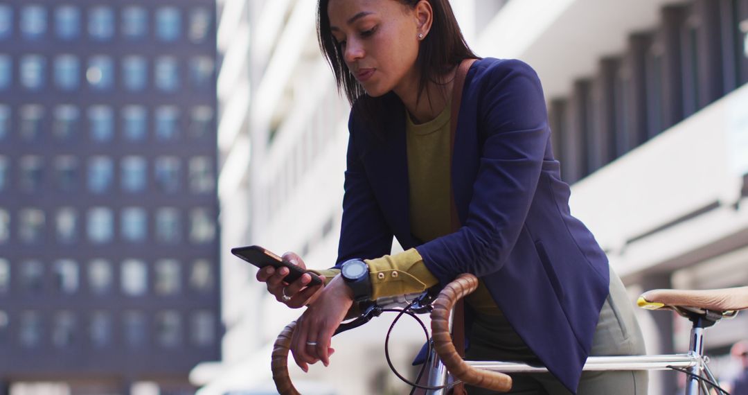 Young professional woman checking smartphone on city street bicycle - Free Images, Stock Photos and Pictures on Pikwizard.com