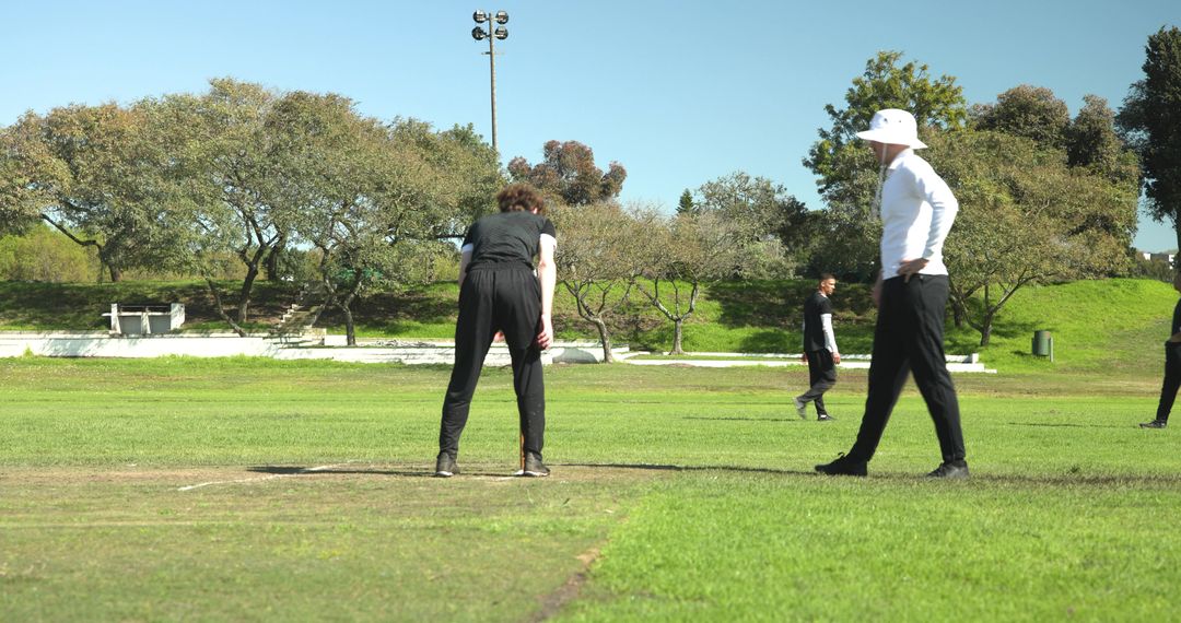 Cricket Enthusiasts Preparing Field on Sunny Day