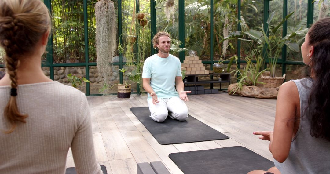 Yoga Instructor Leading Class in Greenhouse Environment