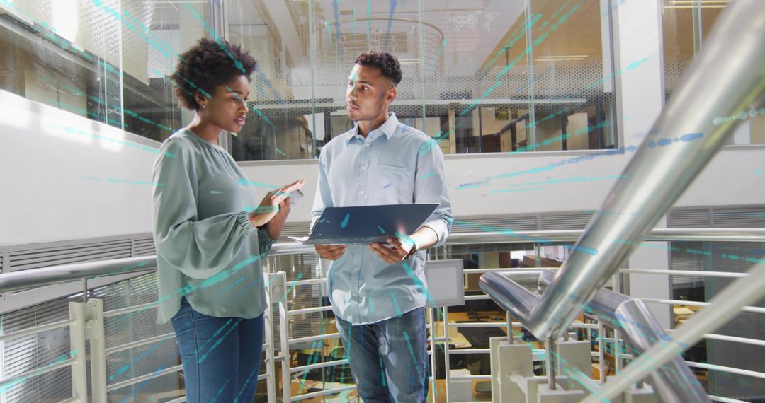 Coworkers Collaborating with Technology in Modern Office Atrium