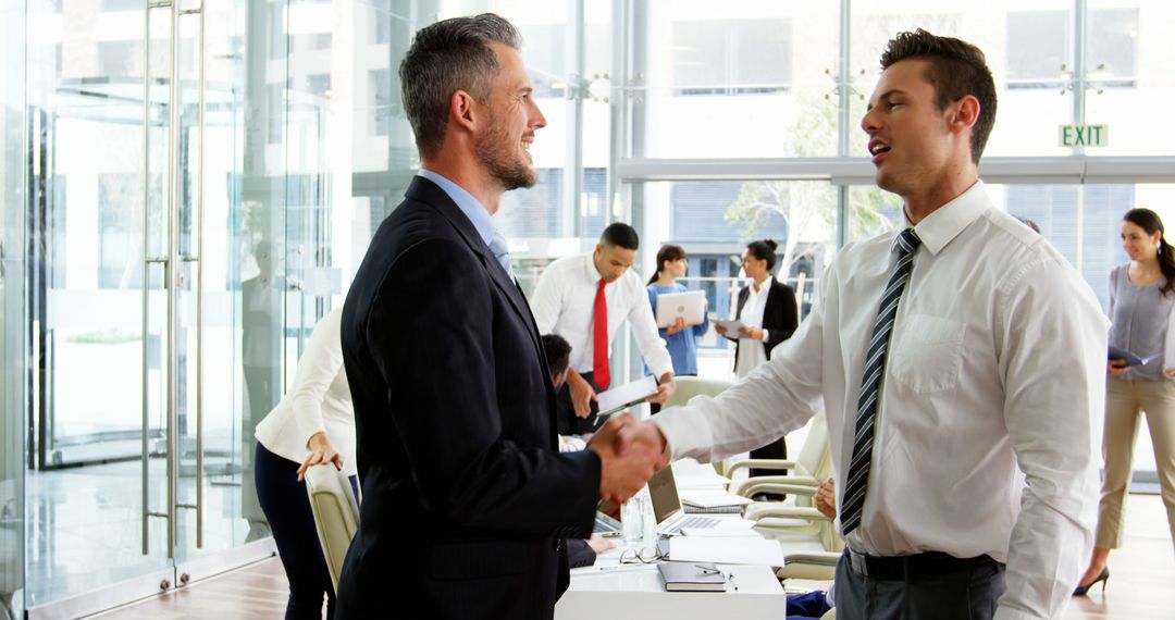 Young executives shaking hands in modern office - Free Images, Stock Photos and Pictures on Pikwizard.com