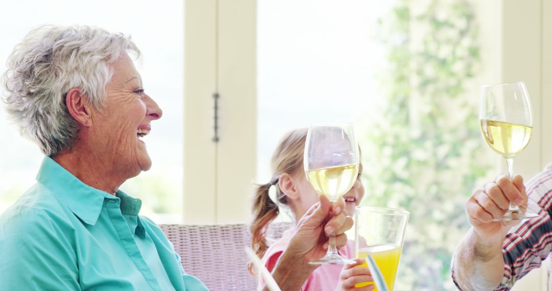 Senior Woman Toasting with Family in Sunny Home - Free Images, Stock Photos and Pictures on Pikwizard.com