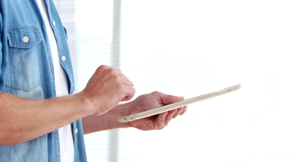 Man Using Digital Tablet in Bright Room - Free Images, Stock Photos and Pictures on Pikwizard.com