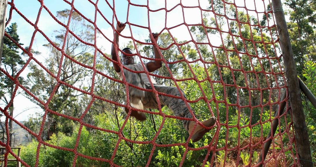 Man Climbing Rope Wall in Outdoor Obstacle Course