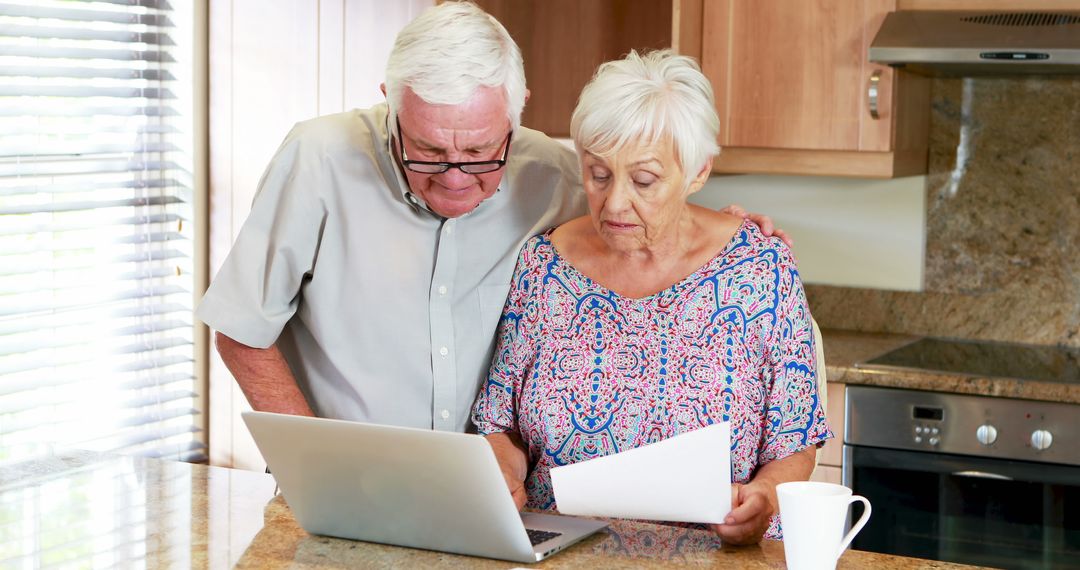 Senior Couple Reviewing Important Documents in Kitchen - Free Images, Stock Photos and Pictures on Pikwizard.com