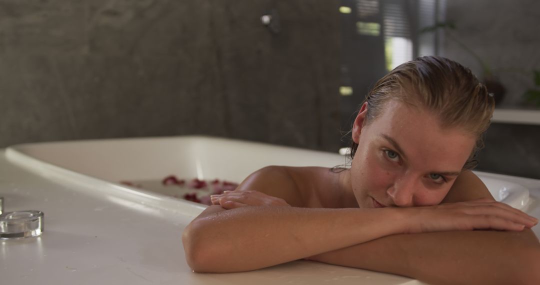 Relaxed Woman Enjoying Bath in Modern Bathroom with Rose Petals - Free Images, Stock Photos and Pictures on Pikwizard.com