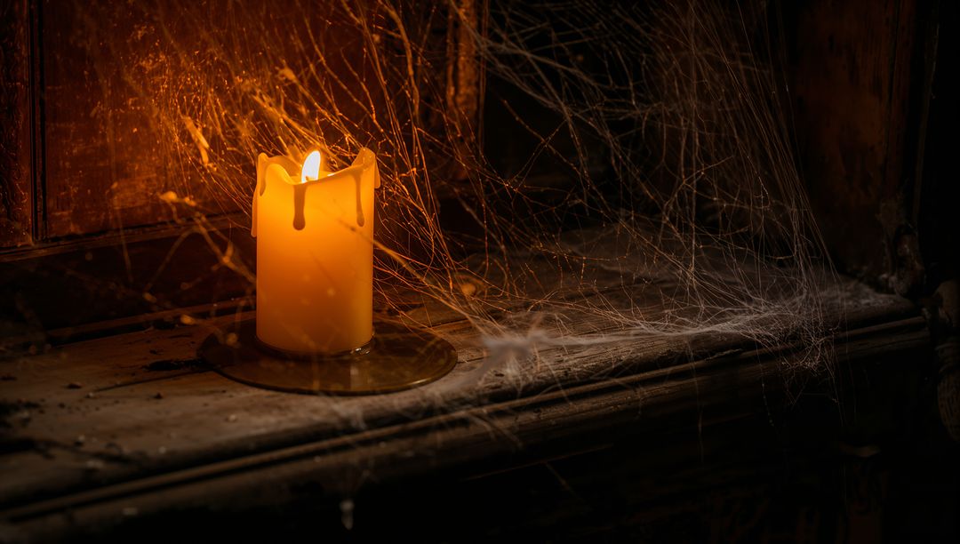 Eerie Candlelight with Spider Webs Creating Moody Atmosphere
