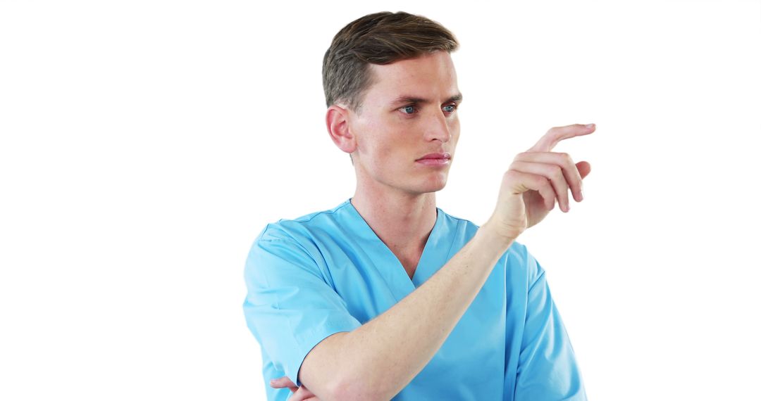 Male Healthcare Professional Interacting with Virtual Screen in Blue Scrubs - Free Images, Stock Photos and Pictures on Pikwizard.com