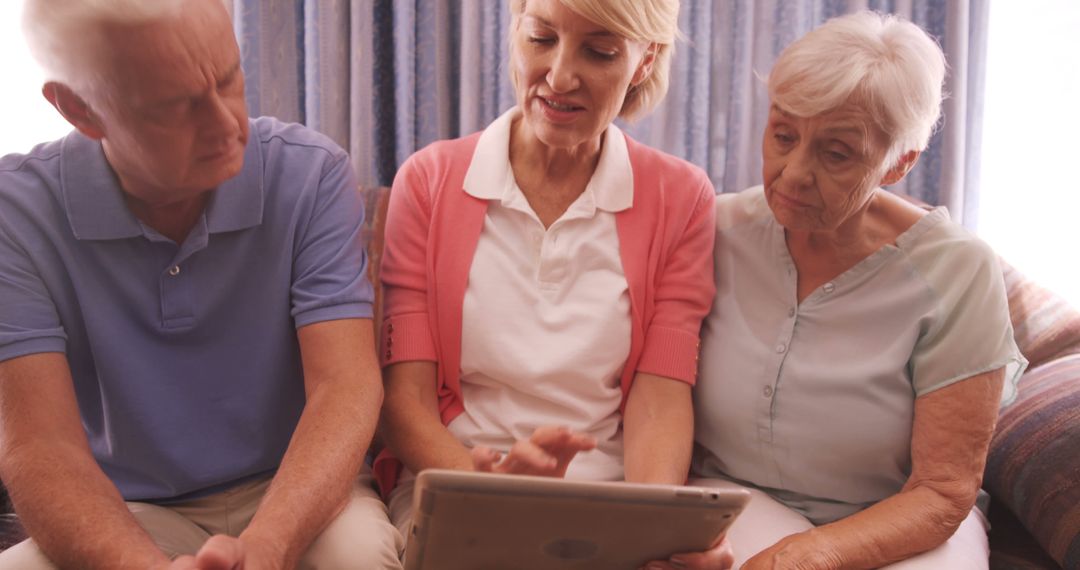 Senior Friends Using Tablet Together on Sofa - Free Images, Stock Photos and Pictures on Pikwizard.com