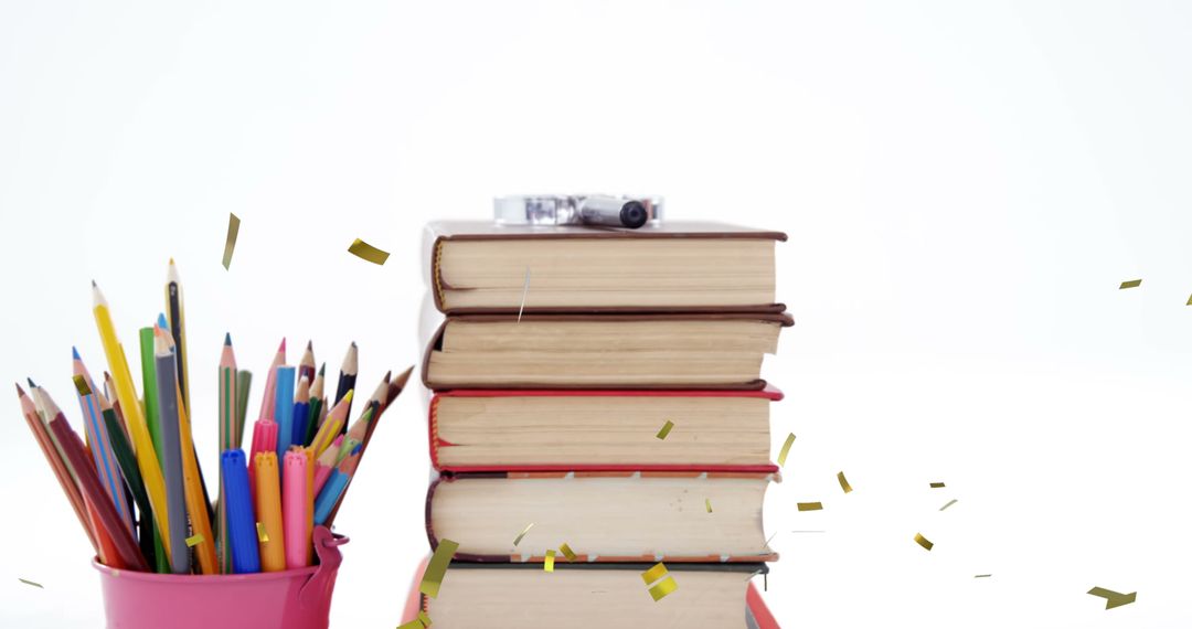 Confetti Falling Over Books and Color Pencils Celebrating Education