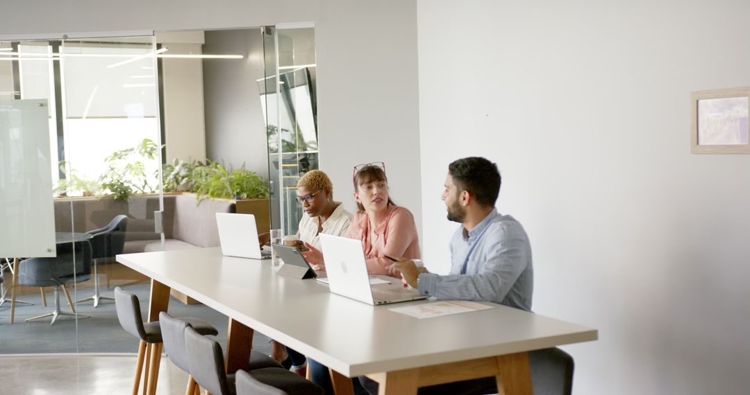 Modern Team Collaboration in Office with Laptops and Discussion