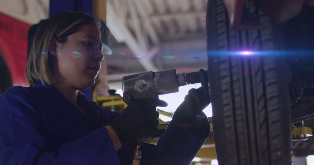 Female Mechanic Using Power Tool for Tire Repair