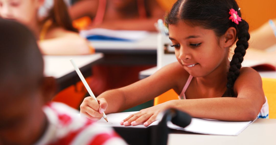 Focused Young Girl Writing in Classroom with Pencil - Free Images, Stock Photos and Pictures on Pikwizard.com