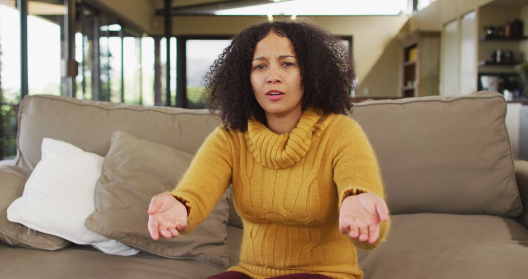 Frustrated Woman with Outstretched Arms Sitting on Couch - Free Images, Stock Photos and Pictures on Pikwizard.com