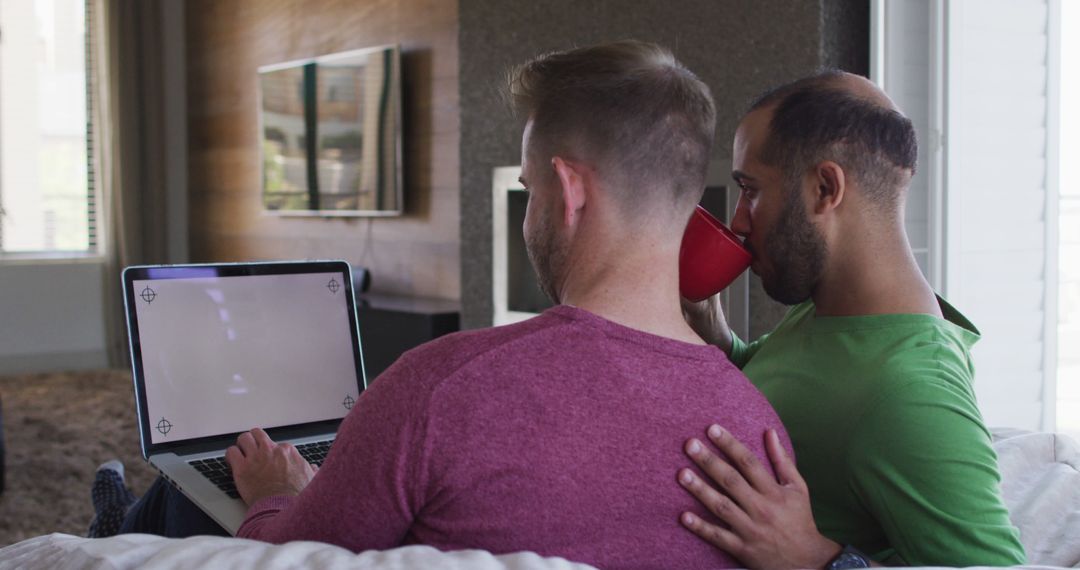 Playful Multiracial Couple Relaxing with Laptop at Home