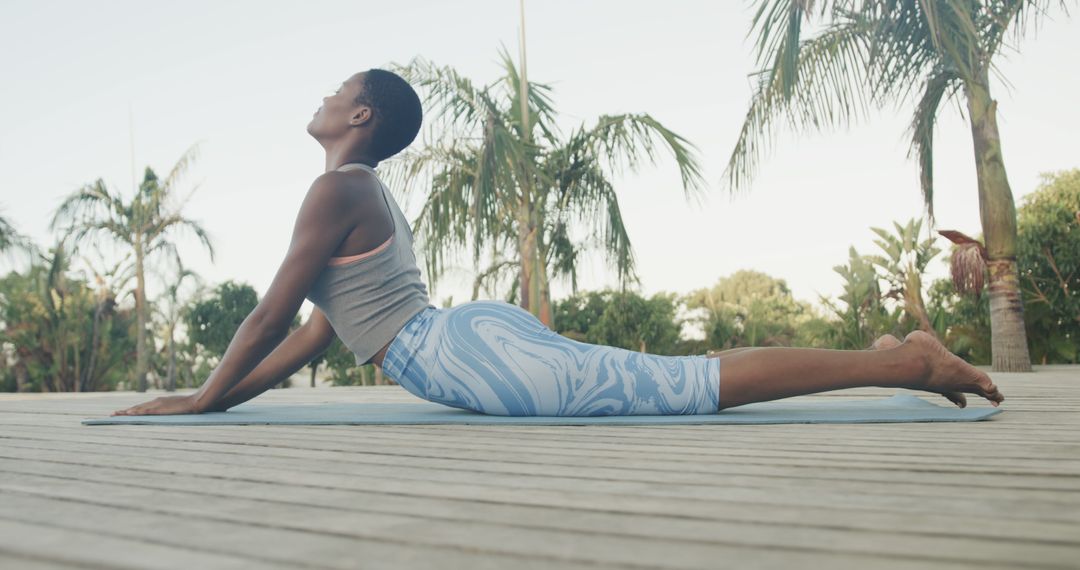 Woman Practicing Cobra Pose Amidst Tropical Setting Outdoor Yoga - Free Images, Stock Photos and Pictures on Pikwizard.com