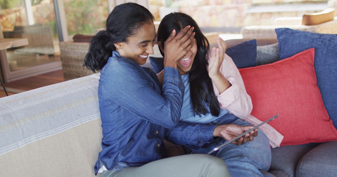 Girls Laughing Together While Using Digital Tablet at Home - Free Images, Stock Photos and Pictures on Pikwizard.com