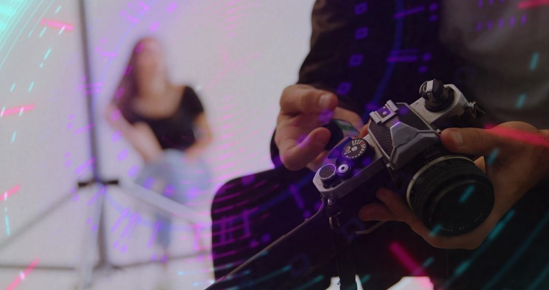 Photographer Adjusting Vintage Camera in Studio with Creative Lighting