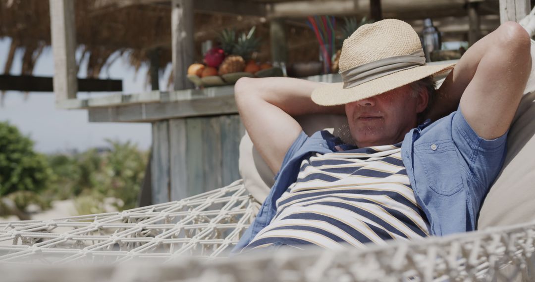 Mature Man Relaxing on Hammock with Straw Hat in Tropical Resort - Free Images, Stock Photos and Pictures on Pikwizard.com