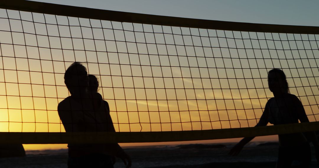 Silhouettes Playing Beach Volleyball at Sunset - Free Images, Stock Photos and Pictures on Pikwizard.com