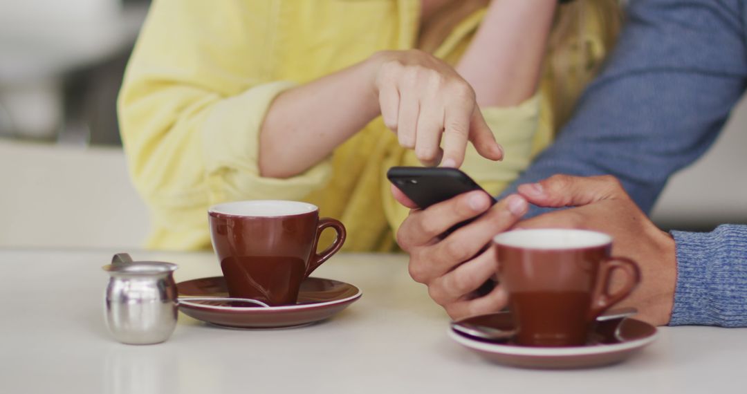 Couple Using Smartphone in Coffee Shop - Free Images, Stock Photos and Pictures on Pikwizard.com