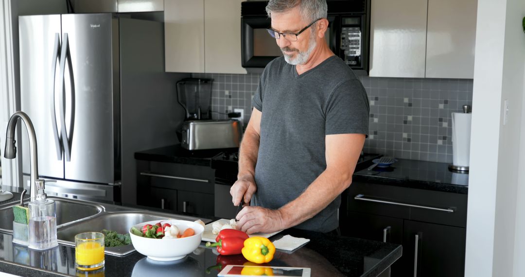 Middle-Aged Man Preparing Healthy Meal in Modern Kitchen - Free Images, Stock Photos and Pictures on Pikwizard.com