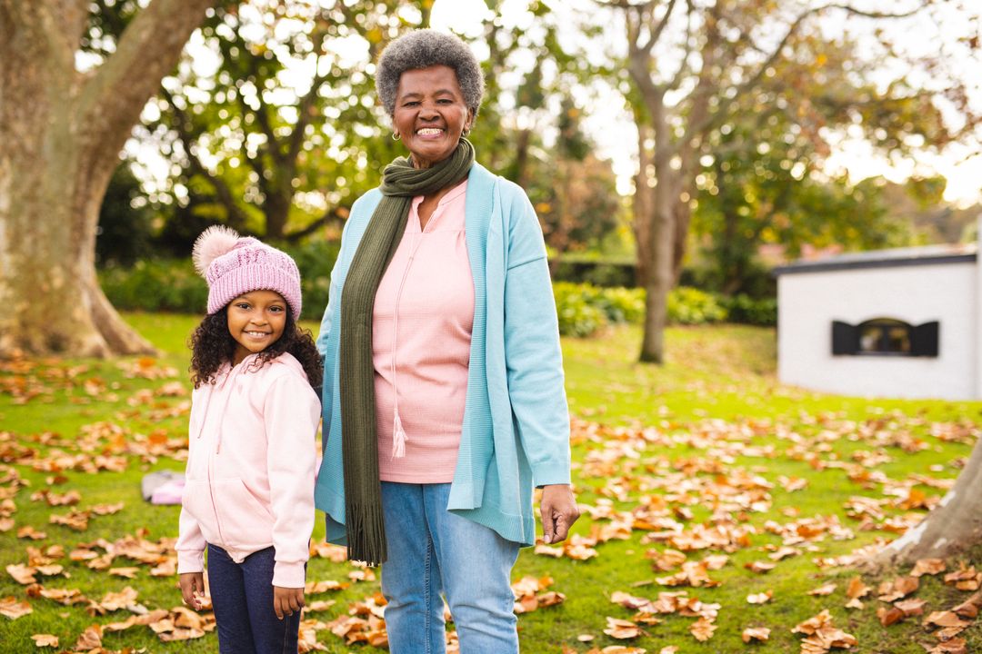 Portrait of smiling african american grandmother with granddaughter standing on land in park - Free Images, Stock Photos and Pictures on Pikwizard.com