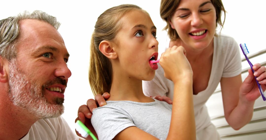 Parents Assisting Daughter with Brushing Teeth in Bathroom - Free Images, Stock Photos and Pictures on Pikwizard.com