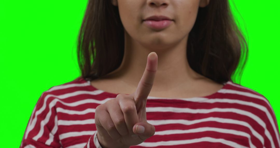 Woman Pointing Finger on Green Background Wearing Striped Shirt - Free Images, Stock Photos and Pictures on Pikwizard.com