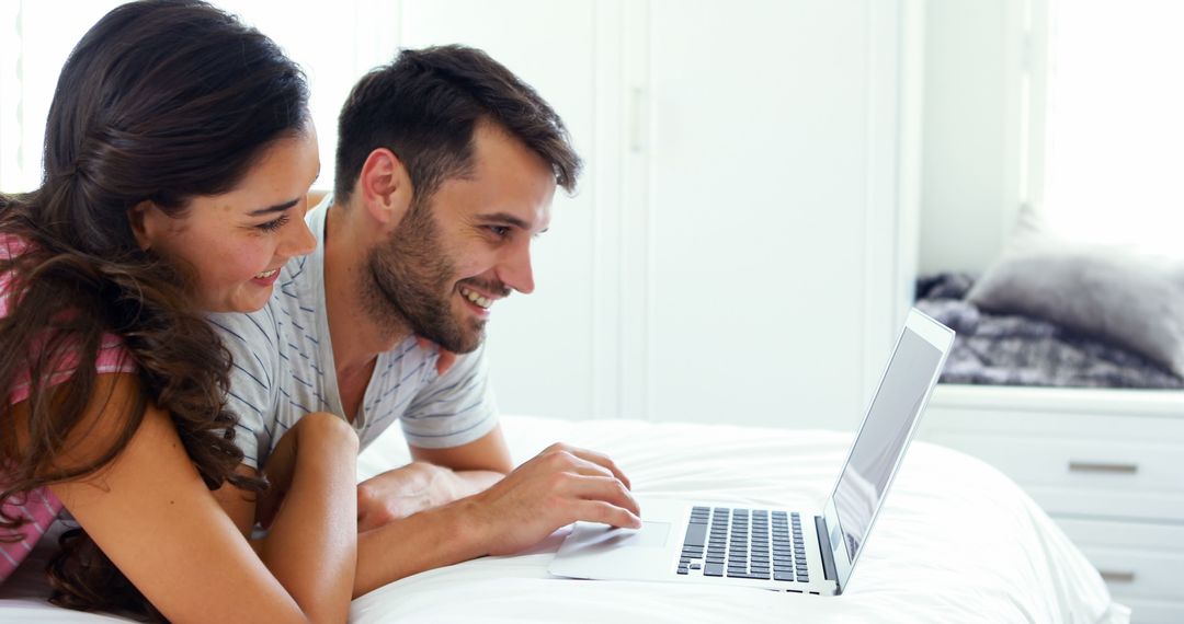 Happy Couple Using Laptop on Bed in Bright Bedroom - Free Images, Stock Photos and Pictures on Pikwizard.com